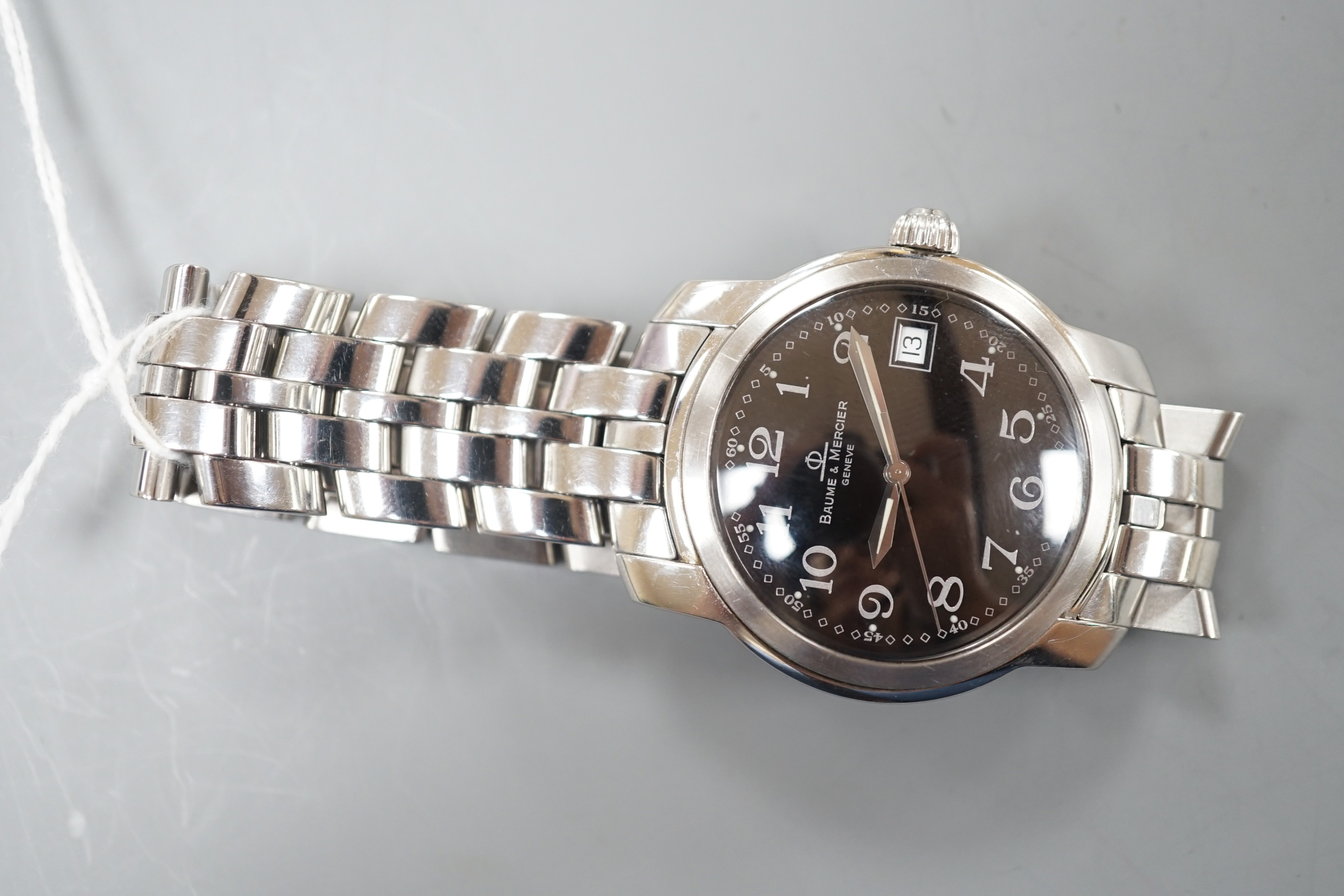 A gentleman's stainless steel Baume & Mercier quartz wrist watch, with black Arabic dial and date aperture, case diameter 37mm, with spare links, no box or papers.